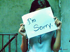 Holding a sign that says I'm Sorry